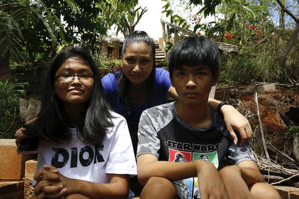 Mary Taboniar, center, a housekeeper at the Hilton Hawaiian Village resort in Honolulu, sits with her children, Mark Daniel Taboniar, 13, and Ma Dennise Taboniar, 12, at their home in Waipahu, Hawaii, on Sept. 4.