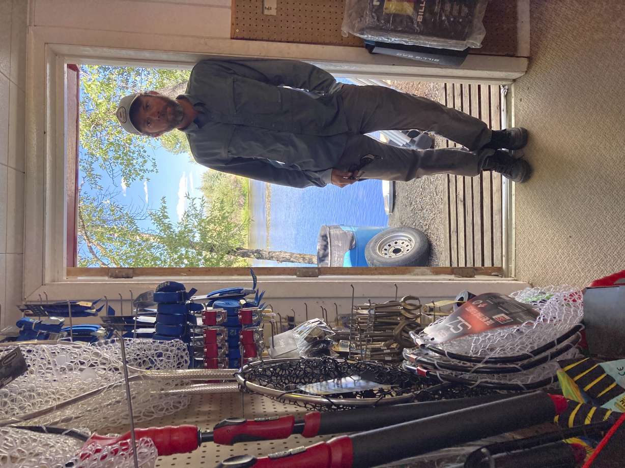 Phil McGrath, owner of Hack's Tackle and Outfitters, stands in a doorway at his store alongside the North Platte River in Saratoga, Wyoming, on Tuesday,Aug. 24, 2021. The upper North Platte is one of several renowned trout streams affected by climate change, which has brought both abnormally dry, and sometimes unusually wet, conditions to the western U.S.