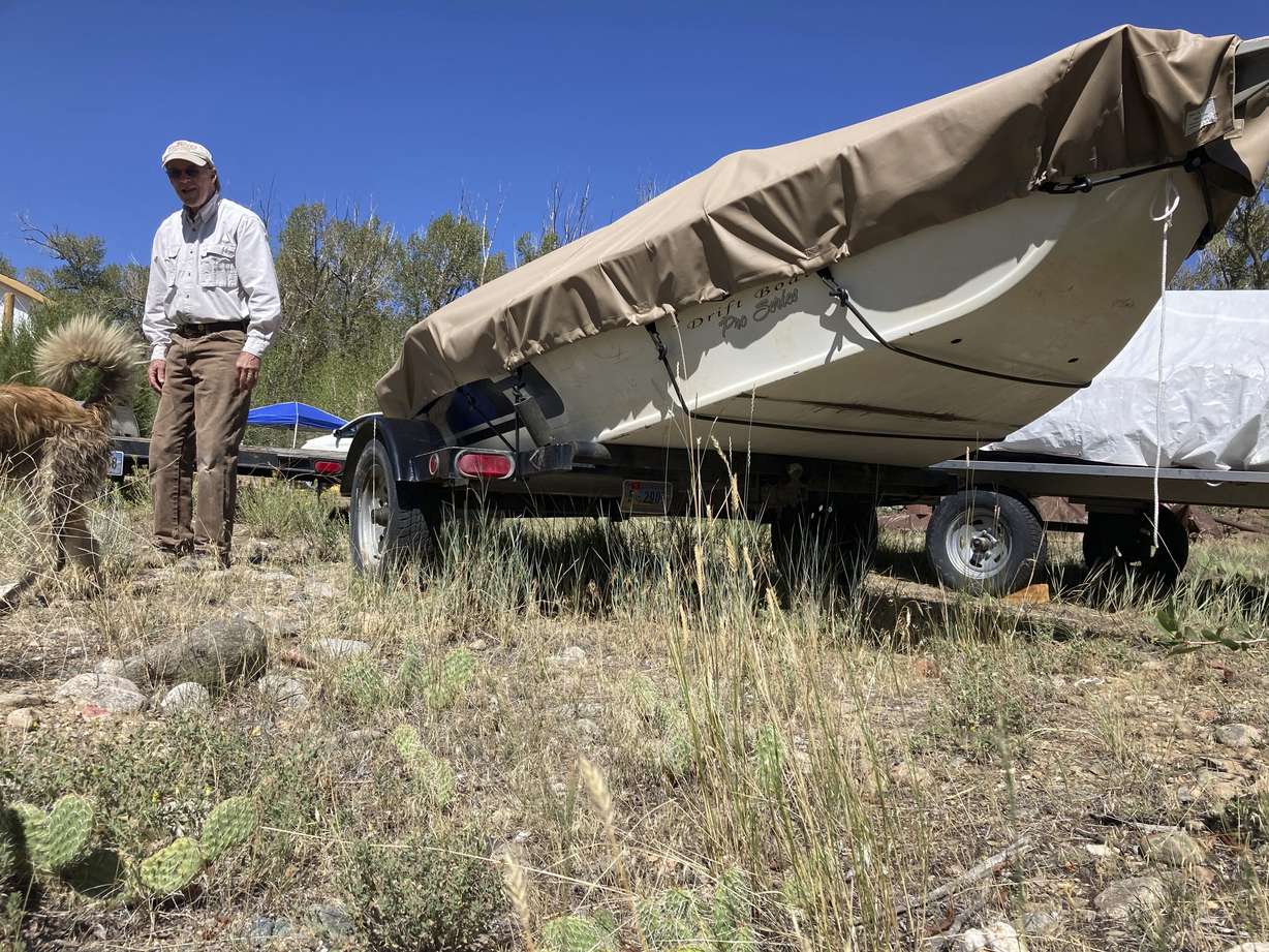Tom Wiersema, who has been trout fishing on the upper North Platte River in Wyoming since the 1970s, stand by his drift boat near Encampment,Wyoming on Tuesday,Aug. 24, 2021. Low water caused Wiersema to stop fishing by boat on a long stretch of the river earlier than usual this year, lest he have to drag his boat over rocks. The upper North Platte is one of several renowned trout streams affected by climate change, which has brought both abnormally dry, and sometimes unusually wet, conditions to the western U.S.
