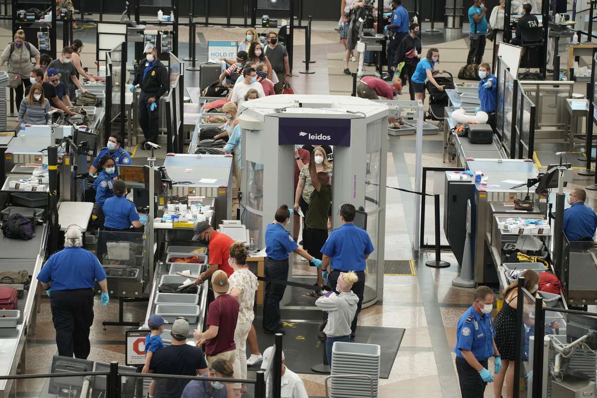 Travelers wear face coverings in the line for the south security checkpoint in the main terminal of Denver International Airport Tuesday, Aug. 24. Two months after the Sept. 11, 2001 attacks, then-President George W. Bush signed legislation creating the Transportation Security Administration, a force of federal airport screeners that replaced the private companies that airlines were hiring to handle security.