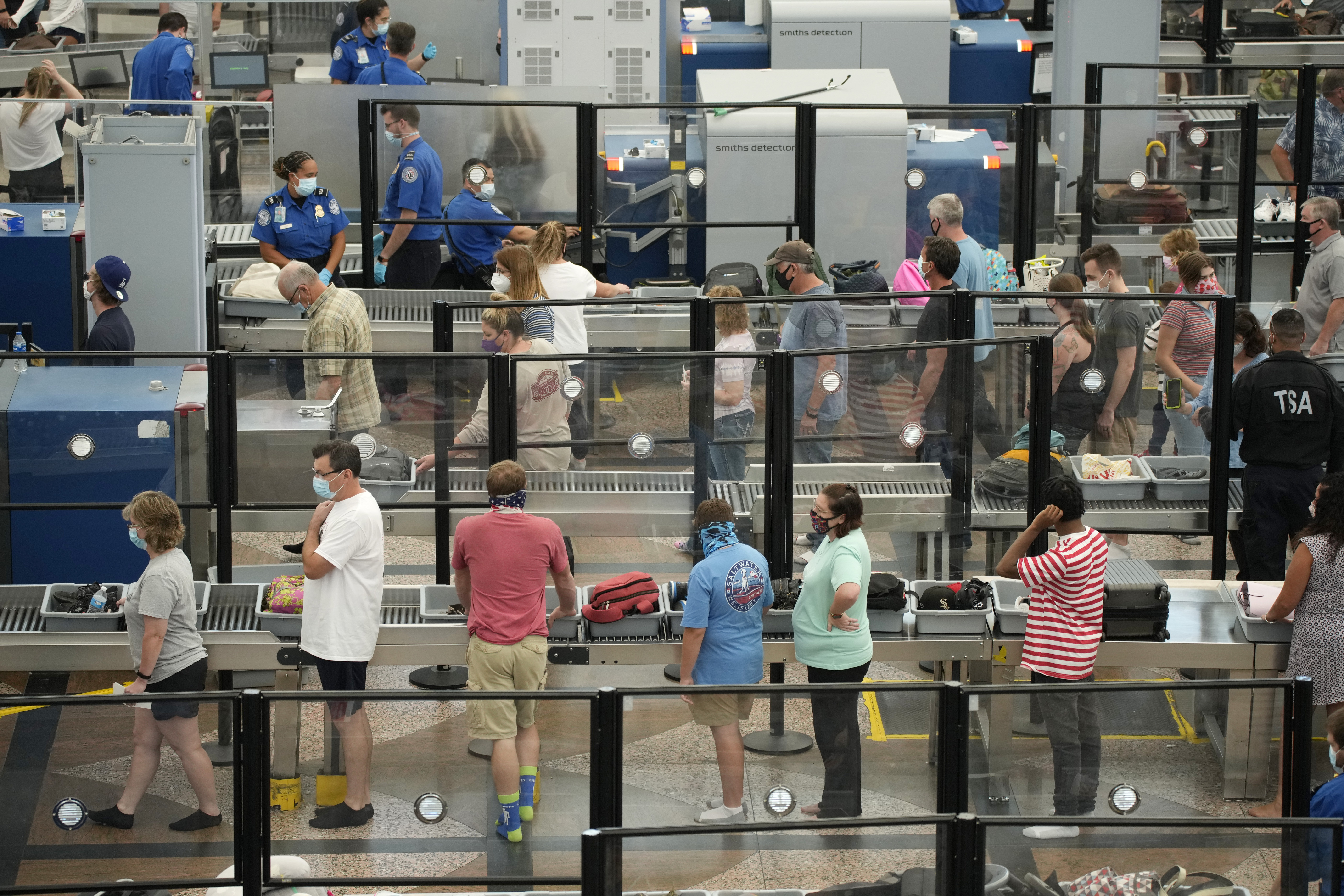 Travelers wear face coverings in the queue for the north security checkpoint in the main terminal of Denver International Airport Tuesday, Aug. 24. Two months after the Sept. 11, 2001 attacks, then-President George W. Bush signed legislation creating the Transportation Security Administration, a force of federal airport screeners that replaced the private companies that airlines were hiring to handle security.