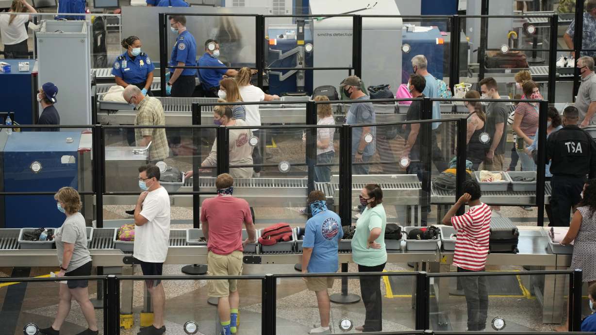 Travelers wear face coverings in the queue for the north security checkpoint in the main terminal of Denver International Airport Tuesday, Aug. 24. Two months after the Sept. 11, 2001 attacks, then-President George W. Bush signed legislation creating the Transportation Security Administration, a force of federal airport screeners that replaced the private companies that airlines were hiring to handle security.