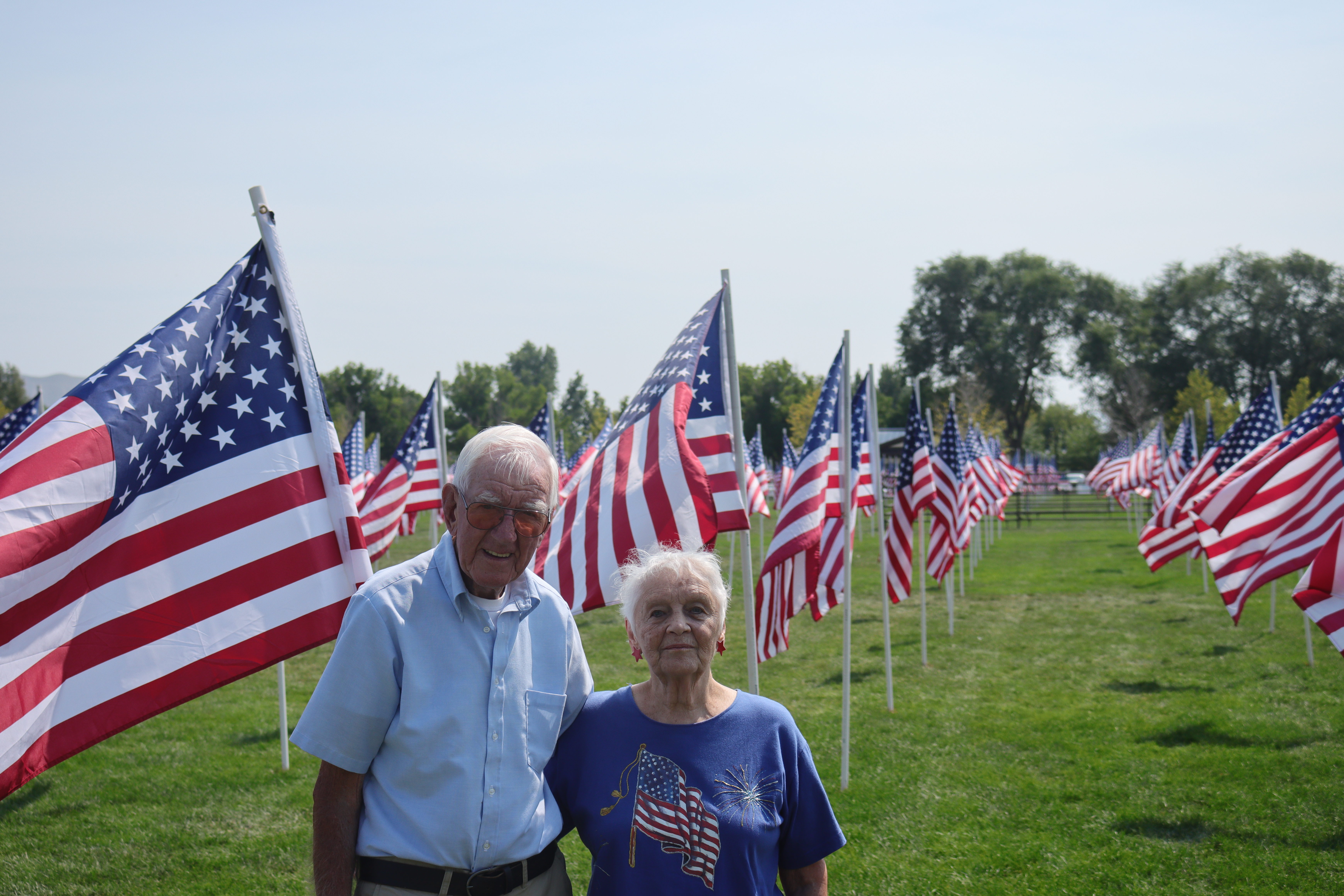 George and Bunny Akins pose in front of a flag display commemorating the 20th anniversary of terrorist attacks on Sept. 11, 2001, at Riverton City Park on Monday.