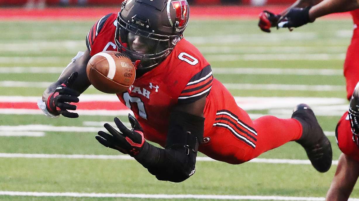 Utah Utes linebacker Devin Lloyd (0) makes a diving interception during the season opener at Rice-Eccles Stadium in Salt Lake City on Thursday, Sept. 2, 2021.
