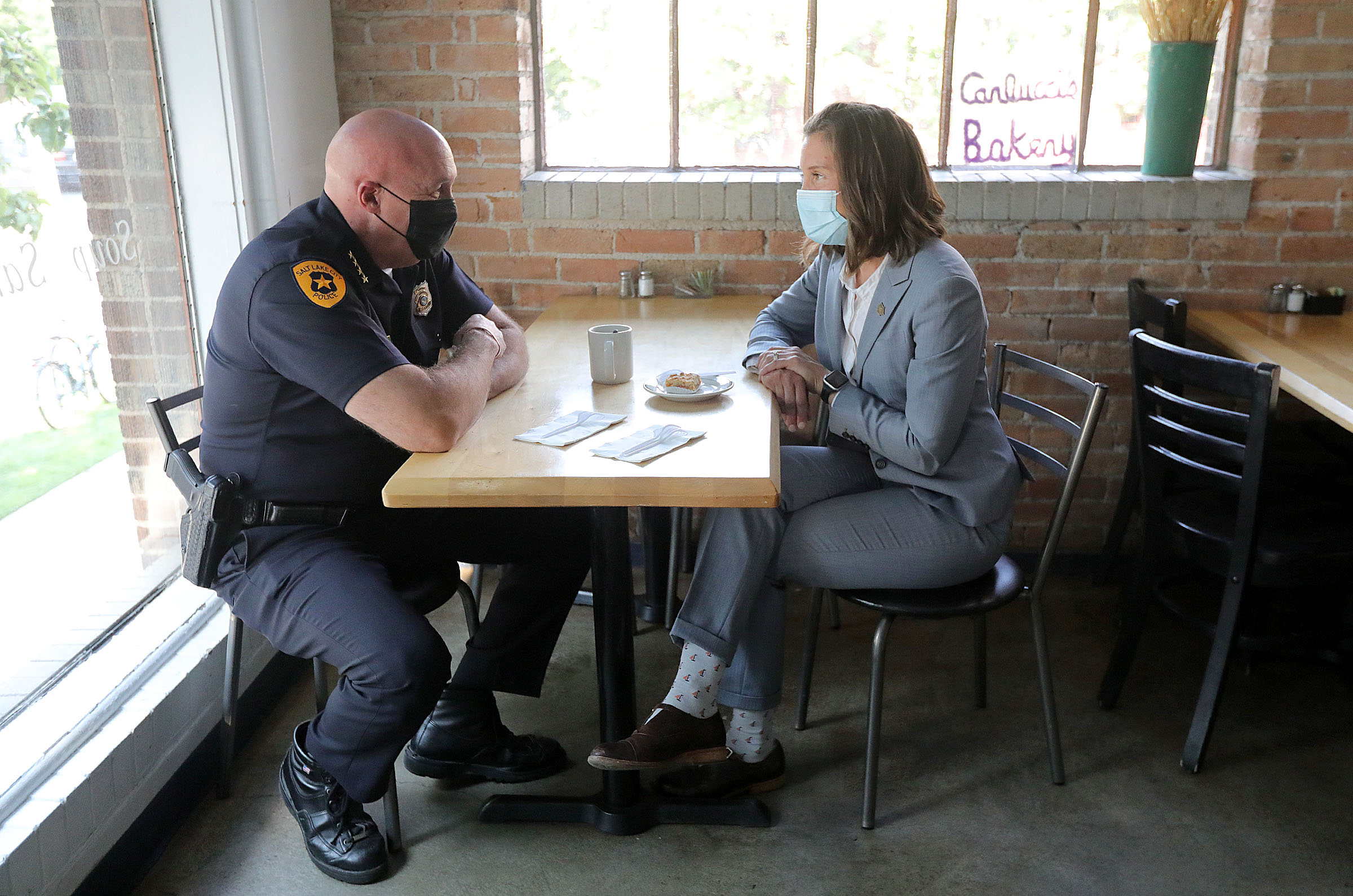 Salt Lake Police Chief Mike Brown, left, and Salt Lake City Mayor Erin Mendenhall talk at Carlucci’s Bakery after a press conference about the city’s crime rates on Tuesday.
