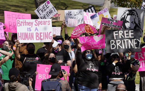 Britney Spears fans hold signs outside a court hearing concerning the pop singer's conservatorship at the Stanley Mosk Courthouse, March 17, 2021, in Los Angeles.