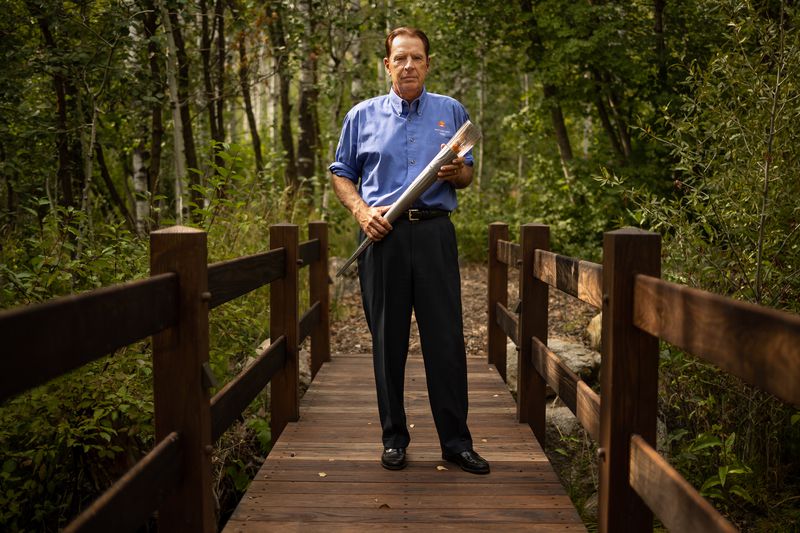 Fraser Bullock, who served as chief operating officer
for the Salt Lake Organizing Committee for the 2002 Winter
Olympics, holds one of that year’s Olympic torches while he poses
for a photograph at his home in Alpine on Tuesday, Aug. 31,
2021.