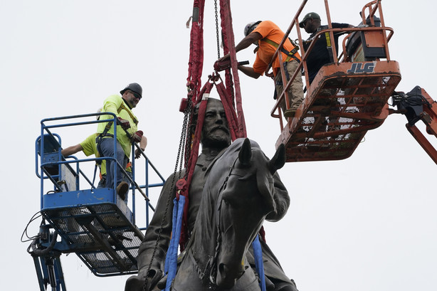Crews work to remove one of the country's largest remaining monuments to the Confederacy, a towering statue of Confederate General Robert E. Lee on Monument Avenue, Wednesday, in Richmond, Va.