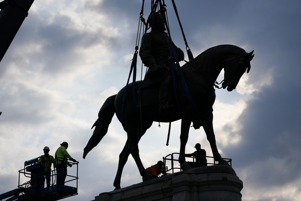 Crews work to remove one of the country's largest remaining monuments to the Confederacy, a towering statue of Confederate General Robert E. Lee on Monument Avenue, Wednesday, in Richmond, Va.