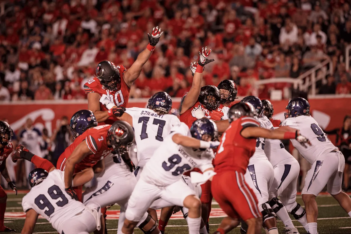 Utah defensive tackle Devin Kaufusi (No. 90) rises high in hopes of knocking down the ball during season-opening victory over Weber State at Rice-Eccles Stadium on Sept. 2. Kaufusi comes from a long line of Kaufusi-playing brothers, cousins and uncles who have donned both red and blue jerseys. 