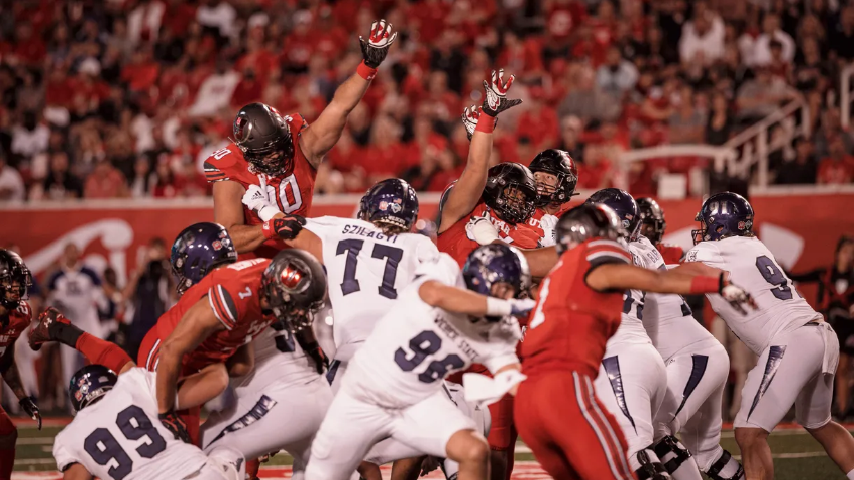 Utah defensive tackle Devin Kaufusi (No. 90) rises high in hopes of knocking down the ball during season-opening victory over Weber State at Rice-Eccles Stadium on Sept. 2. Kaufusi comes from a long line of Kaufusi-playing brothers, cousins and uncles who have donned both red and blue jerseys.
