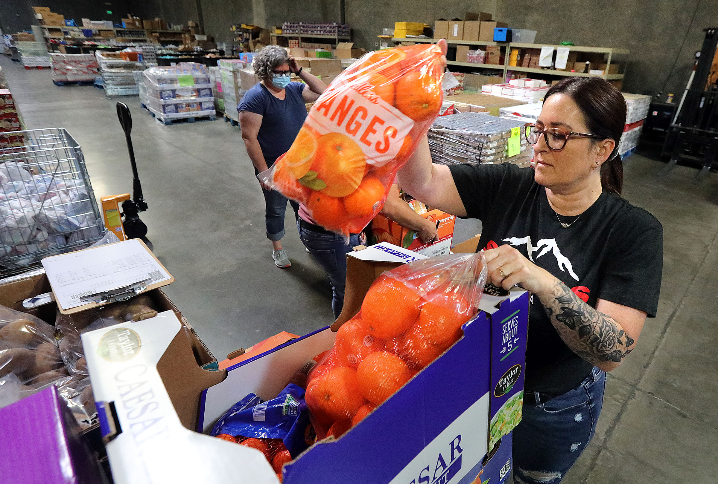 DeAnn Kelsey, Granite Education Foundation warehouse assistant, sorts fresh food donations into boxes for specific schools at the warehouse in South Salt Lake on Wednesday. A new program will offer fresh, healthy food to families in need in the Granite School District, which officials say has faced an ever-growing issue of food insecurity with the pandemic's progression.