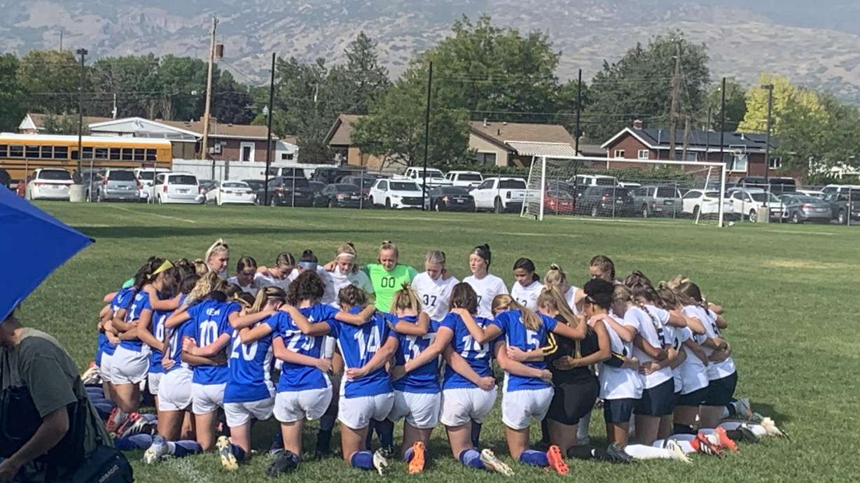 The Timpanogos High School varsity girls soccer team kneels in prayer with the opposing Orem High School team to pray for an Orem High player who got injured Tuesday.