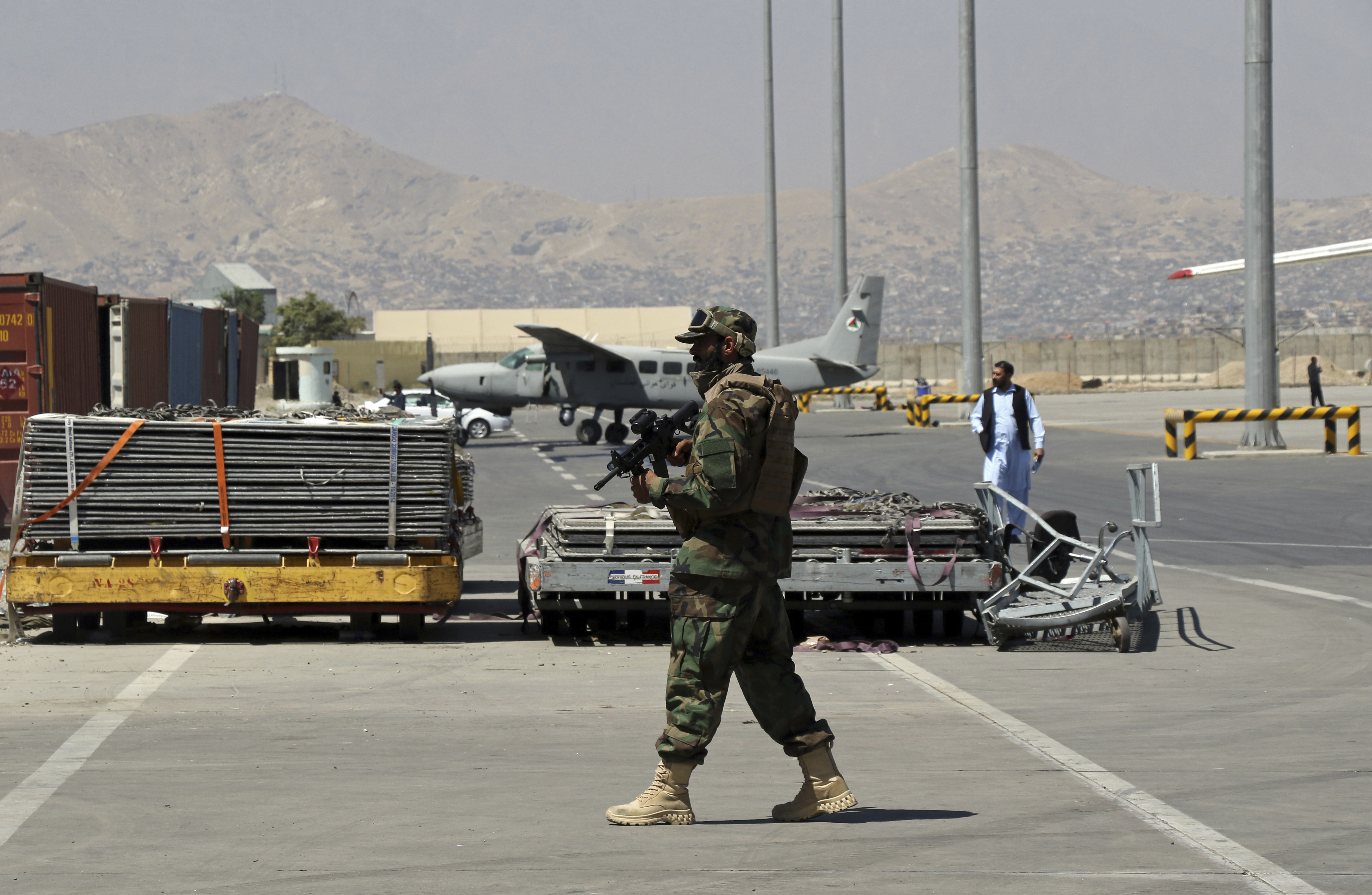 A Taliban soldier walks at Hamid Karzai International Airport in Kabul, Afghanistan, Sunday. Taliban authorities will allow between 100 and 150 Westerners, including Americans, to fly out from Kabul Thursday.