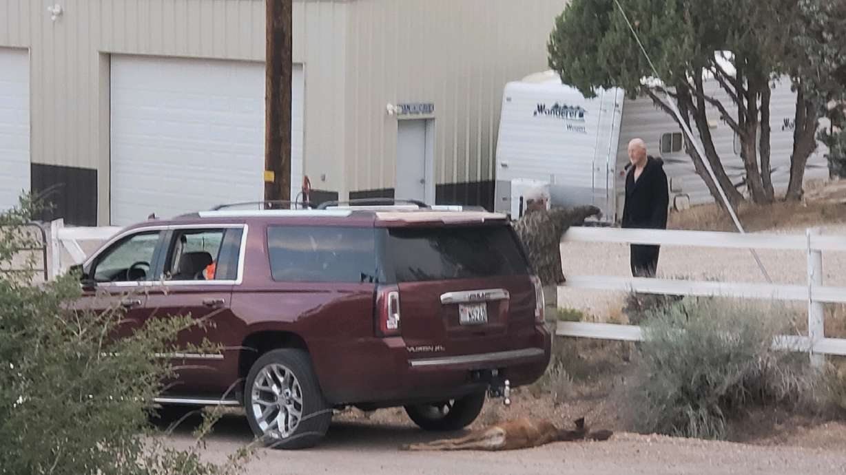 In this photo submitted to St. George News, a deer carcass is visible beneath a GMC Yukon as state Rep. Travis Seegmiller, R-St. George, speaks with Kelly Reber, a property owner in rural Washington County, on Aug. 13.