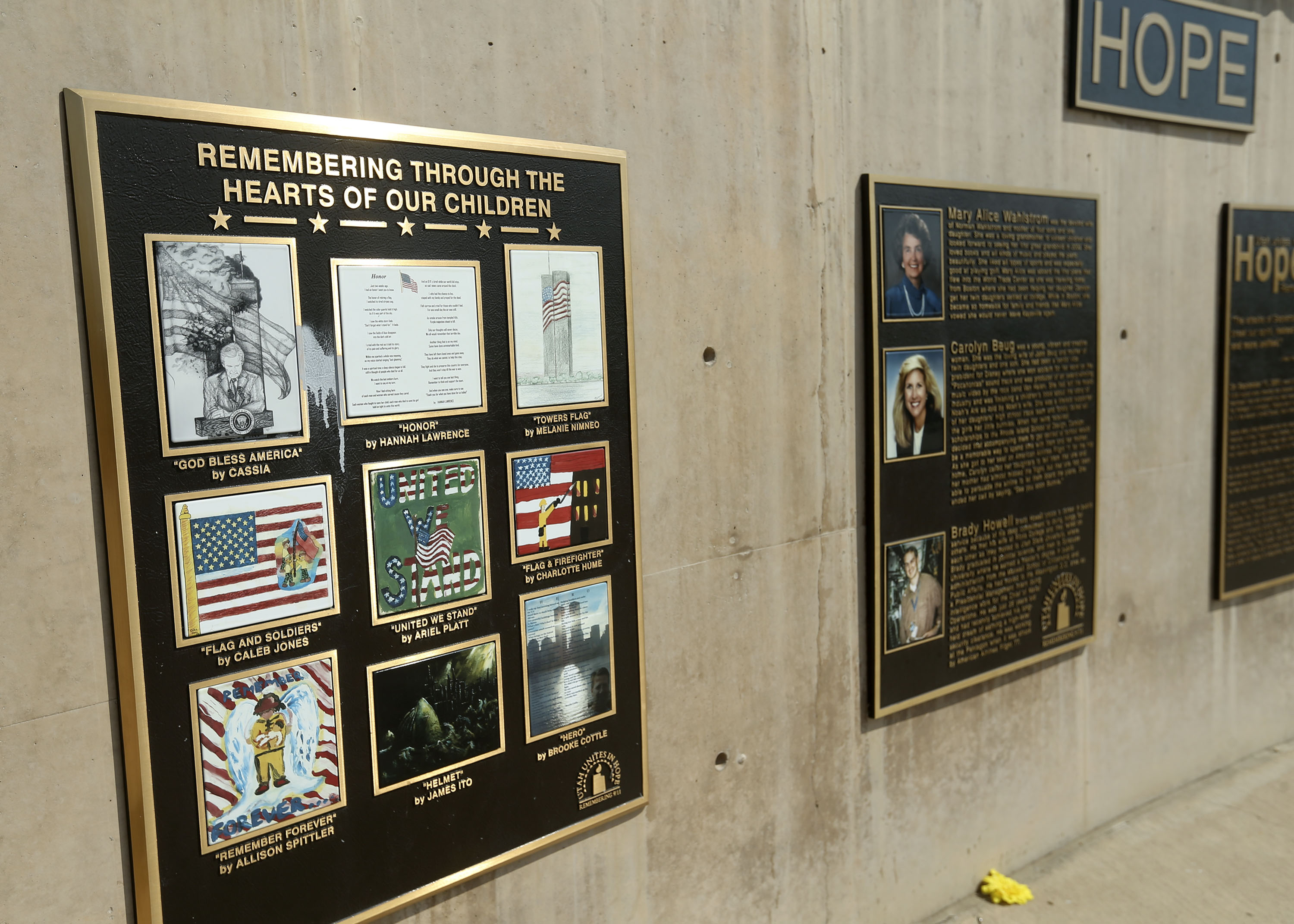New photographs have replaced the old, faded and cracked photographs on the brass plaques at the 9/11 memorial at the Utah State University Botanical Center in Kaysville on Thursday.