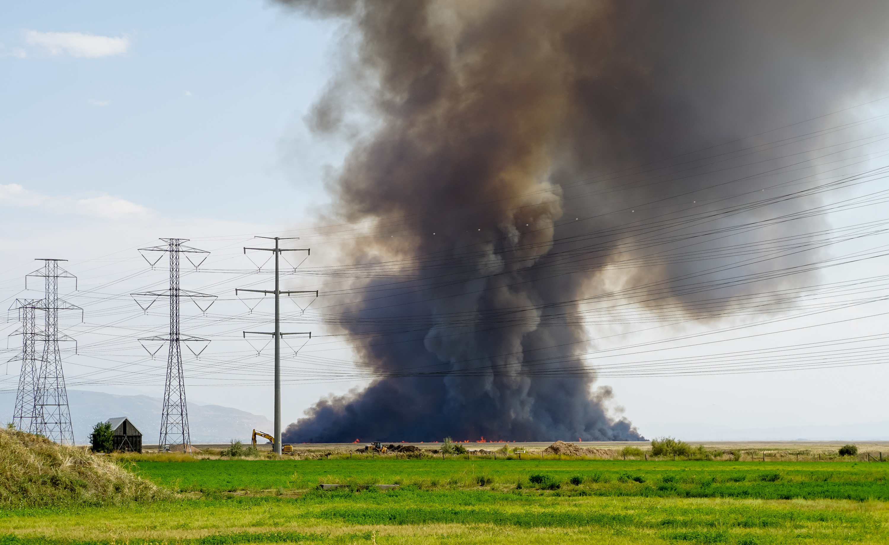 A fire burns in the wetlands west of Kaysville and Farmington on Friday.