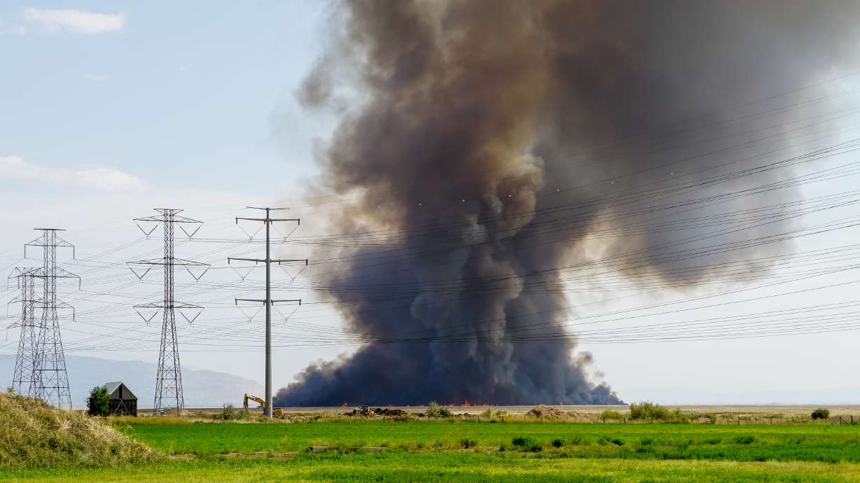 A fire burns in the wetlands west of Kaysville and Farmington on Friday.