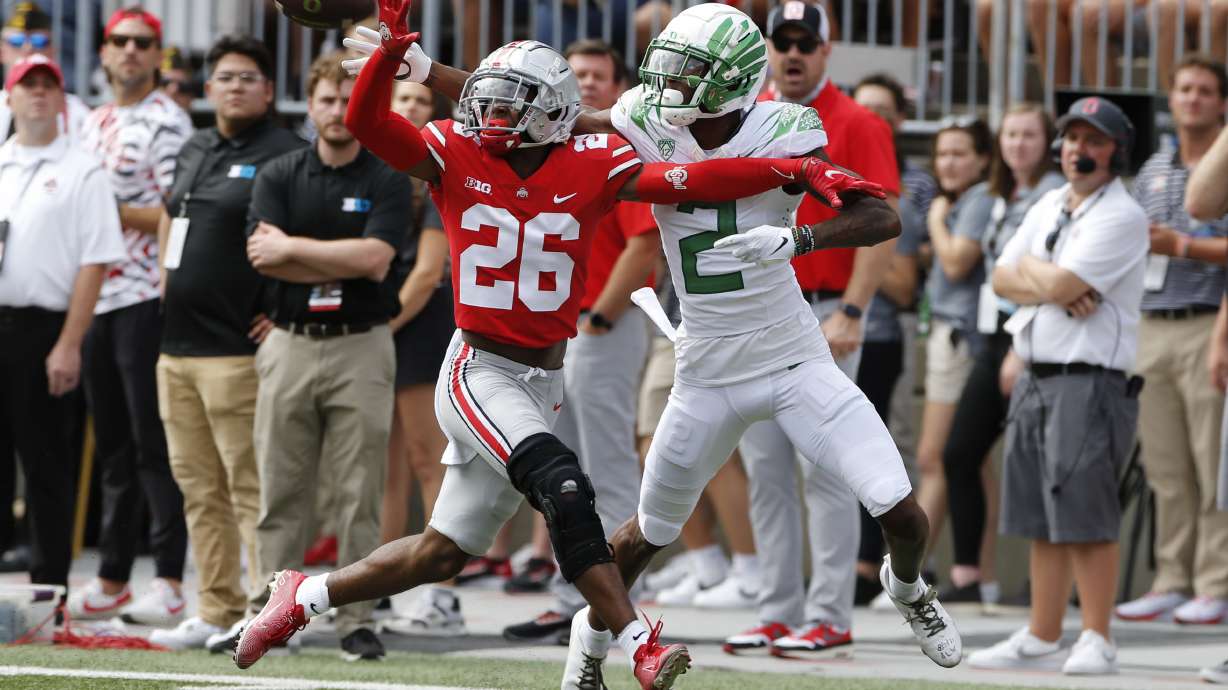 Ohio State defensive back Cameron Brown, left, knocks the ball away from Oregon receiver Devon Williams during the first half of an NCAA college football game Saturday, Sept. 11, 2021, in Columbus, Ohio.