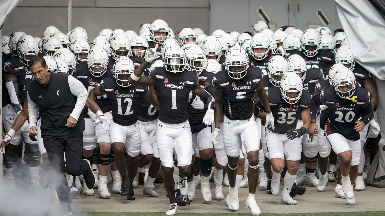 Cincinnati head coach Luke Fickell, left, and Ahmad Gardner (1) lead players onto the field prior to an NCAA college football game against Murray State, Saturday, Sept. 11, 2021, in Cincinnati.