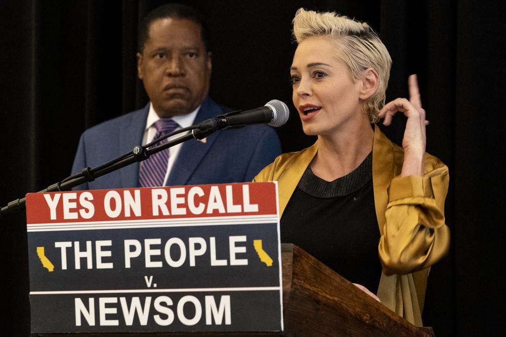 Republican conservative radio talk show host Larry Elder, left, listens as former actress and activist Rose McGowan speaks during as the pair hold a news conference at the Luxe Hotel Sunset Boulevard in Los Angeles on Sunday. Elder is running to replace Democratic Gov. Gavin Newsom in the Sept. 14 recall election. McGowan, who is known for her role in the "Scream" movie franchise, was one of the earliest of dozens of women to accuse Hollywood producer Harvey Weinstein of sexual misconduct, making her a major figure in the #MeToo movement.