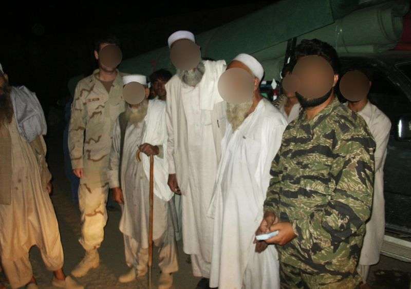 Eric Eliason, a former Utah National Guard chaplain and
now a Brigham Young University professor, left, meets with village
elders and an Afghan interpreter, whose faces have been blurred for
their safety, during Eliason’s deployment in 2004.