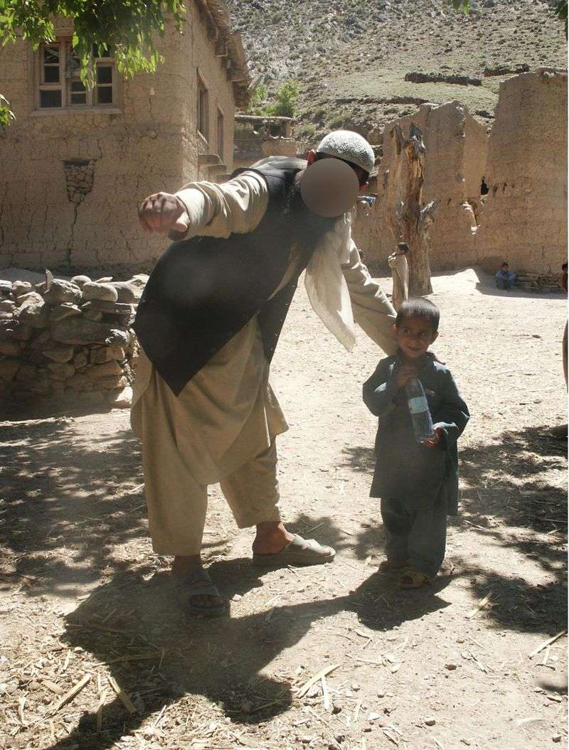 Taroon, whose face has been blurred for his family’s
safety, helps a child look for his soccer ball in an Afghan village
near the Pakistani border during former Utah National Guard
chaplain Eric Eliason’s deployment in 2004. Taroon was murdered by
the Taliban in the late 2000s. Eliason, now a Brigham Young
University professor, and several former military friends are
working to help Taroon’s wife, daughter, two sons and brother
escape Afghanistan.