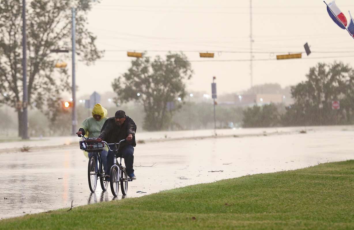 Cyclist make their way down a street in Bay City, Texas, as Tropical Storm Nicholas approaches on Monday, Sept. 13, 2021.