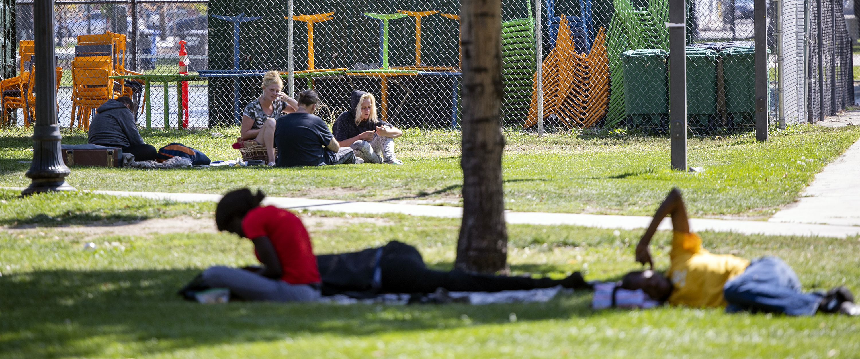 People sit and sleep at Pioneer Park in Salt Lake City on Tuesday. The Pioneer Park Coalition on Tuesday called for immediate action to address the rise in crime and other illegal activities that go on in and around the park.