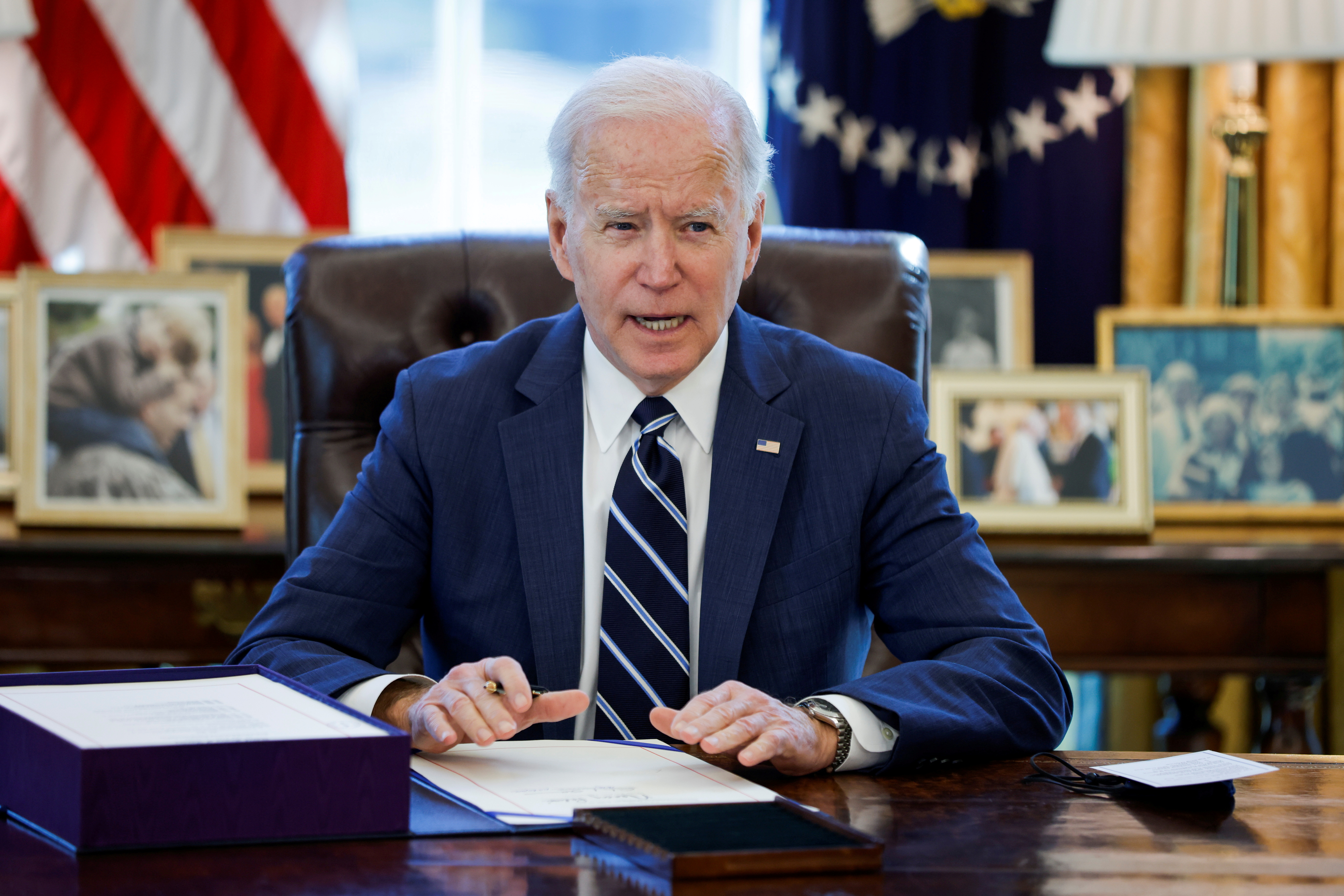 President Joe Biden signs the American Rescue Plan inside the Oval Office at the White House in Washington on March 11. A one-year expansion of the U.S. child tax credit, touted by Biden, has disproportionately benefited states that voted for former President Donald Trump in 2020, a review finds.