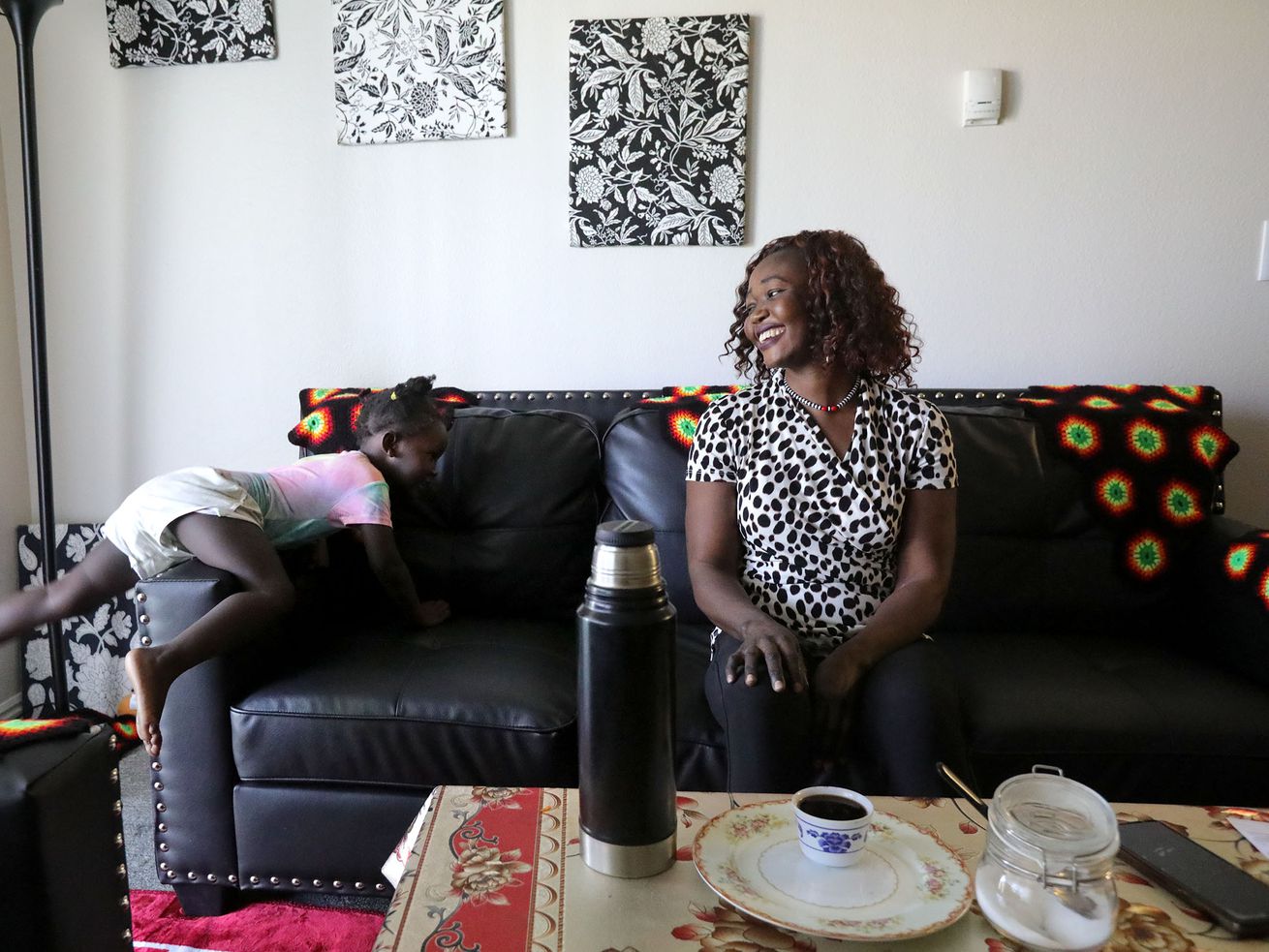 Siyanna Inna climbs on the couch as her mother, Tabitha
Kwayge, a Sudanese refugee, laughs at their apartment in Midvale on
Wednesday. Kwayge is looking for another place for
her family to live as the $1,500 monthly rent is too expensive.