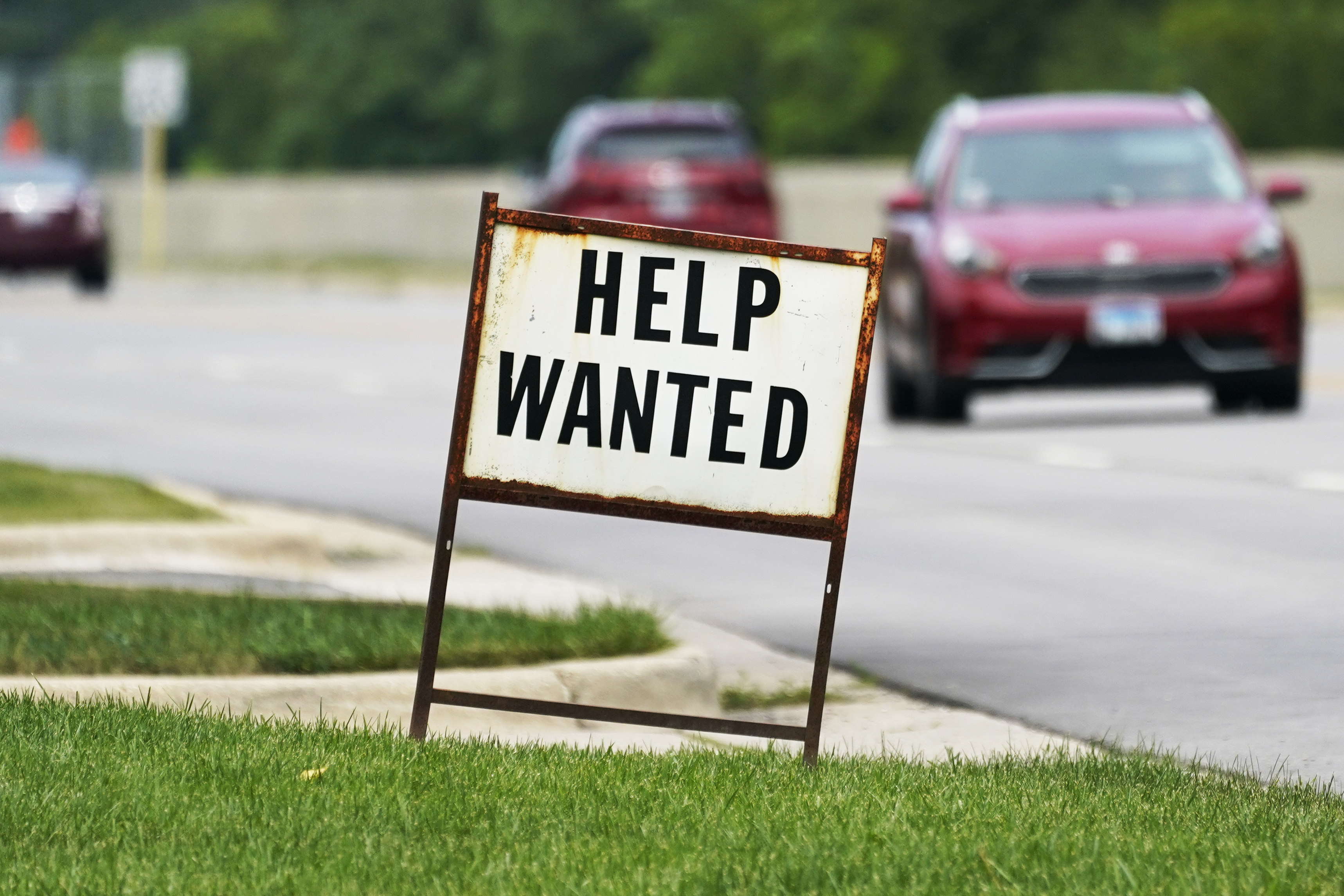 A help-wanted sign is displayed at a gas station in Mount Prospect, Ill. July 27. The number of Americans seeking unemployment benefits moved up last week to 332,000.
