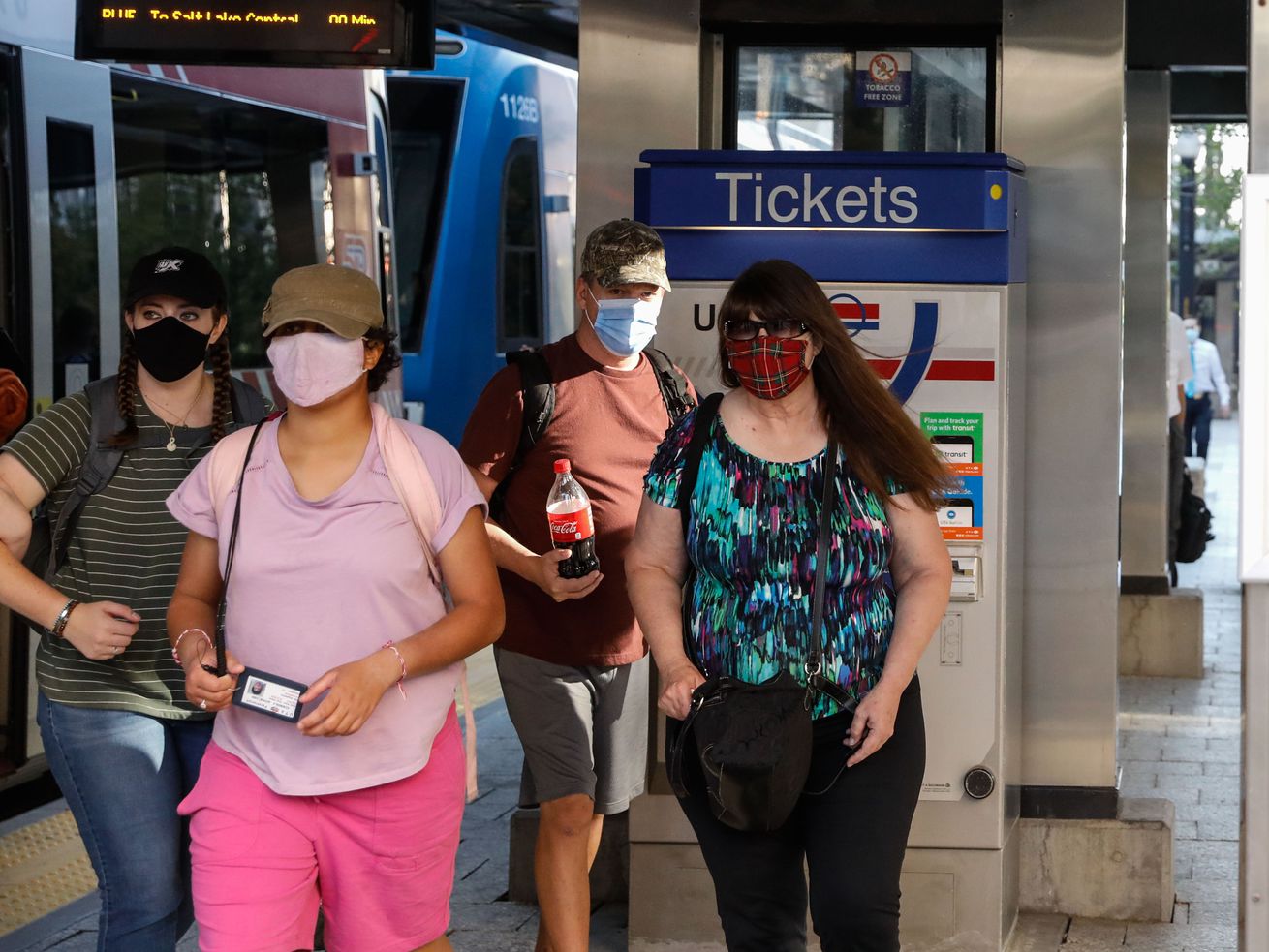 Utah Transit Authority riders wearing masks navigate the TRAX platform at the City Center Station in Salt Lake City on
Wednesday.