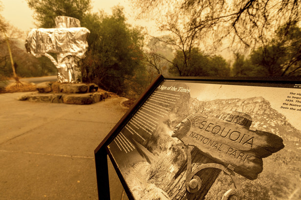 Fire-resistant wrap covers a historic welcome sign as the KNP Complex Fire burns in Sequoia National Park, Calif., on Wednesday. The blaze is burning near the Giant Forest, home to more than 2,000 giant sequoias.