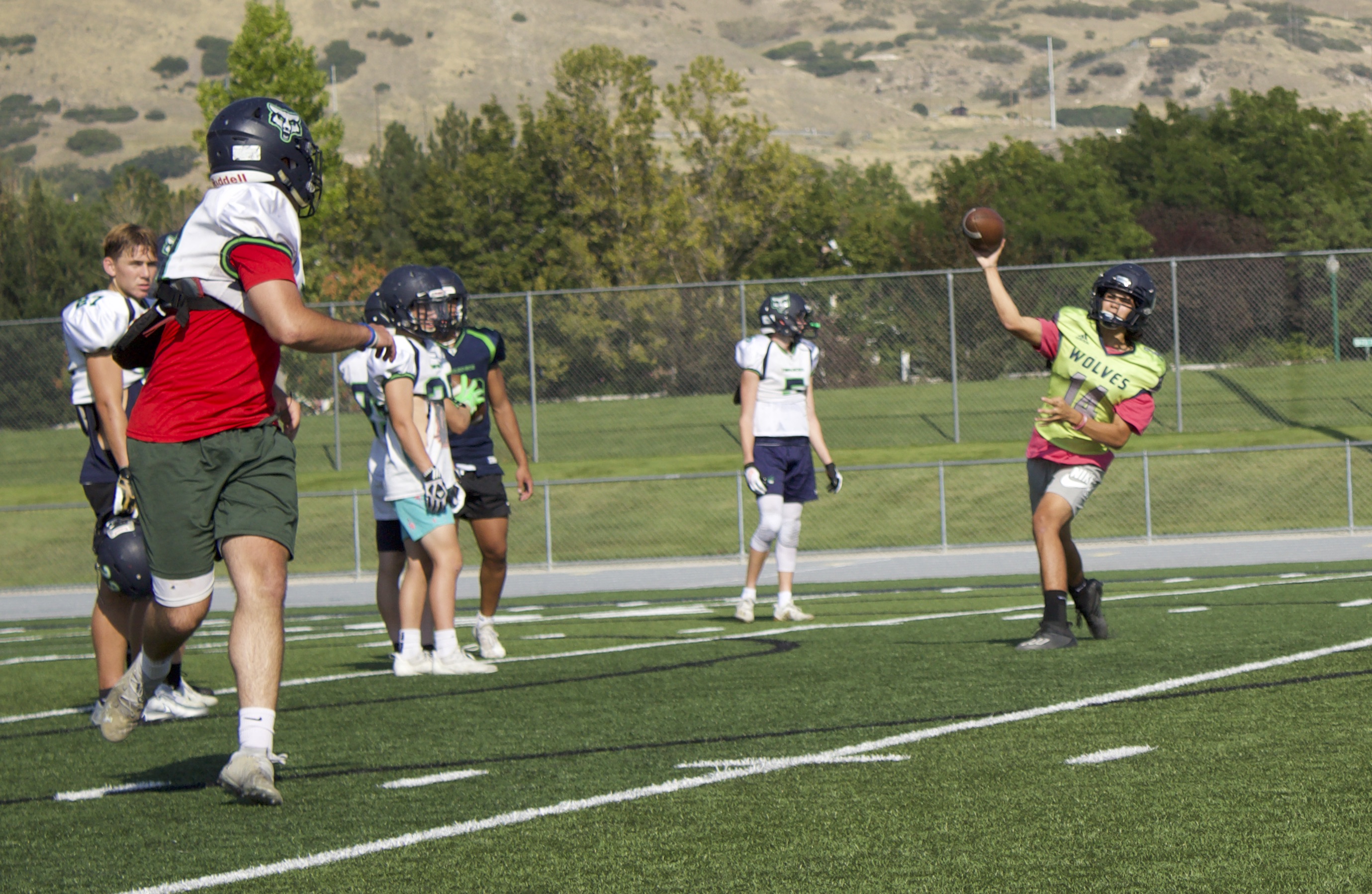 Timpanogos quarterback Matu Holdaway (14) throws a pass to running back Josh Jones (81) during practice in Orem. The Timberwolves are off to a 5-0 start, their best since 2018 and one of just three years in the past seven with at least as many total wins.