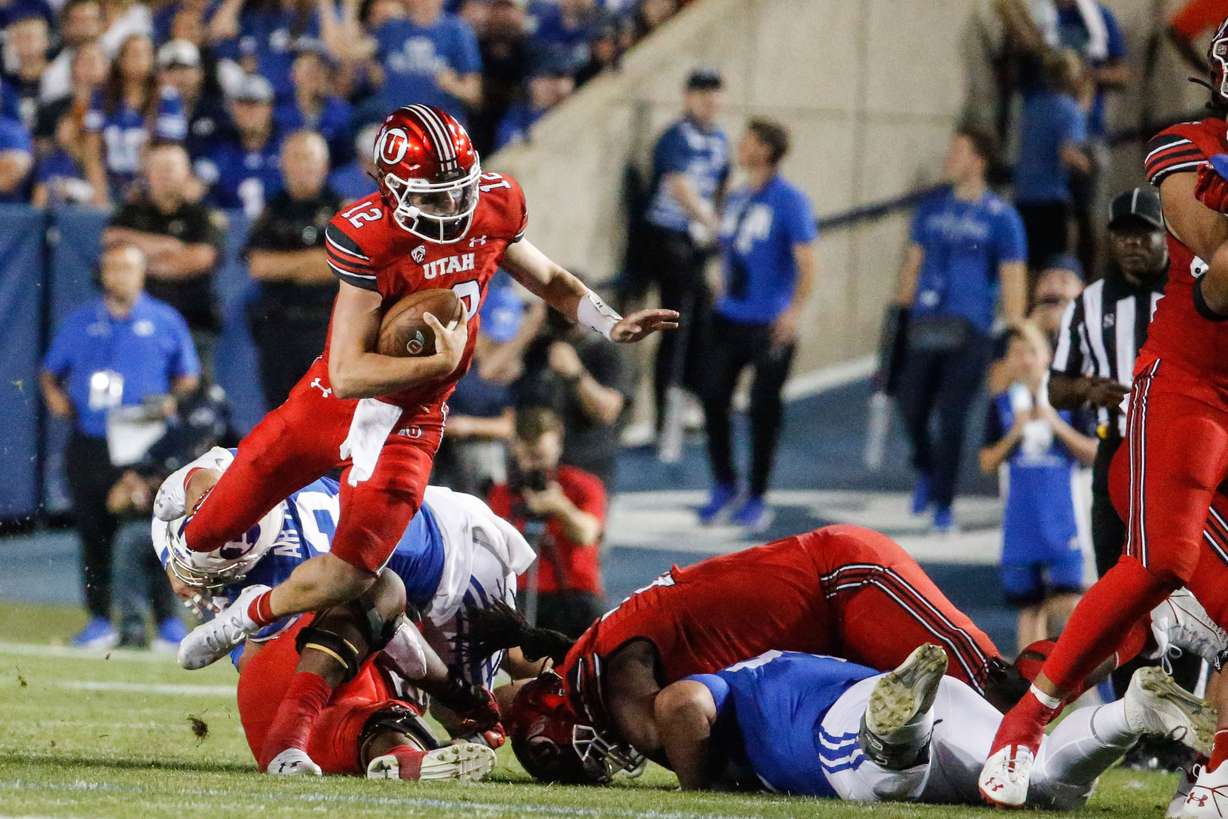 Utah Utes quarterback Charlie Brewer dodges a tackle during the first half of an NCAA college football game against BYU at LaVell Edwards Stadium in Provo on Saturday, Sept. 11, 2021.
