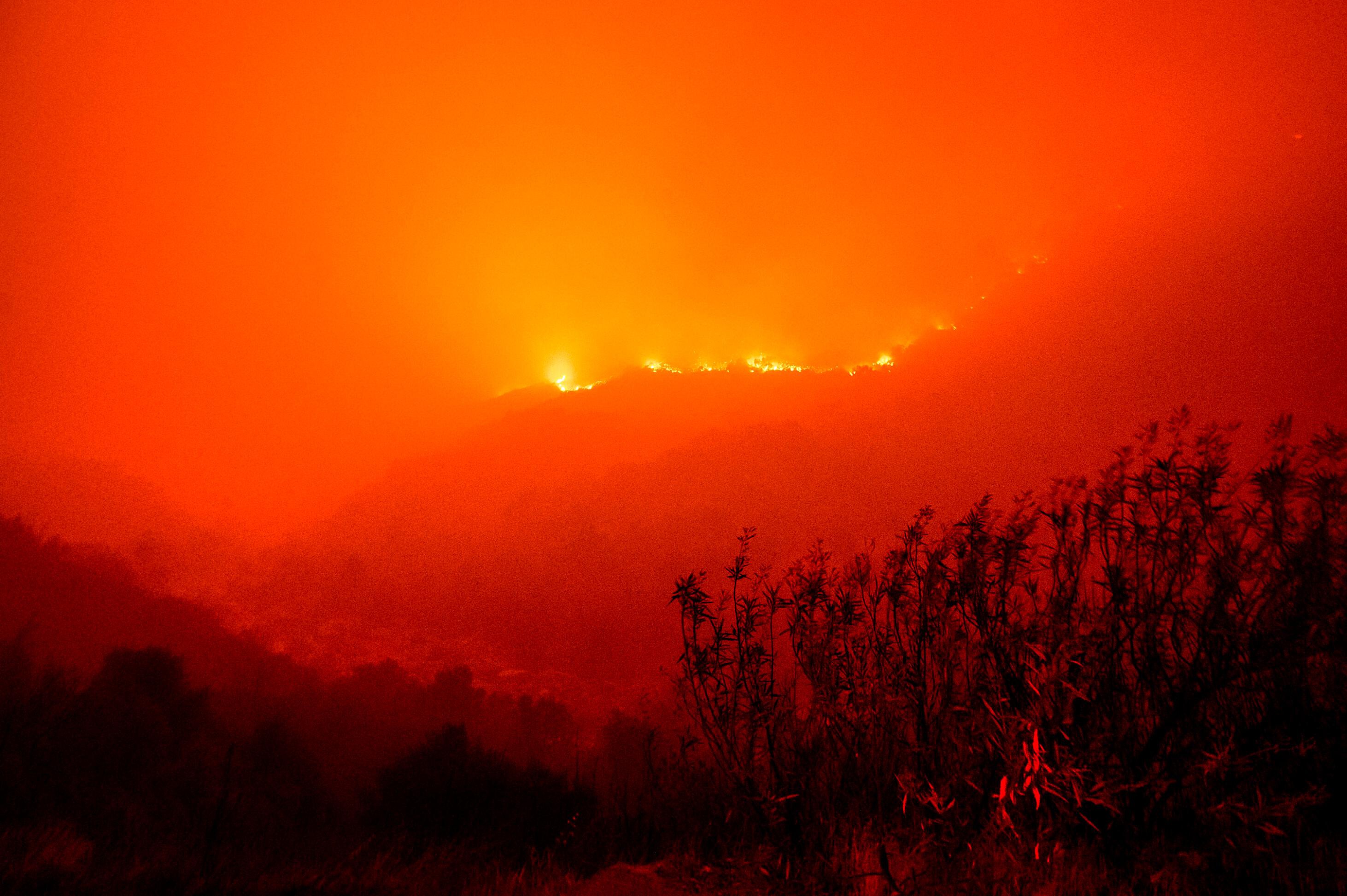 Flames from the KNP Complex Fire burn along a hillside above the Kaweah River in Sequoia National Park, California on Sept. 14, 2021.  The blaze burned dangerously close to the Giant Forest, which is home to more than 2,000 giant sequoias.