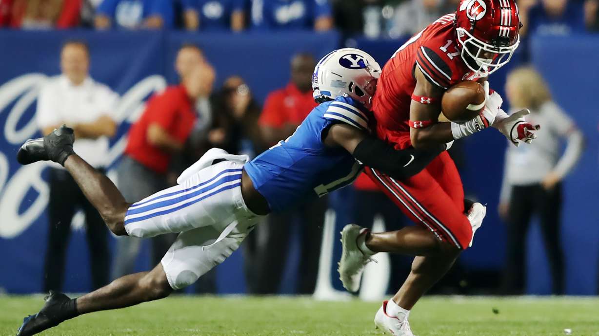 Brigham Young Cougars defensive back Isaiah Herron (11) makes a tackle on Utah Utes wide receiver Devaughn Vele (17) during an NCAA football game at LaVell Edwards Stadium in Provo on Saturday, Sept. 11, 2021.