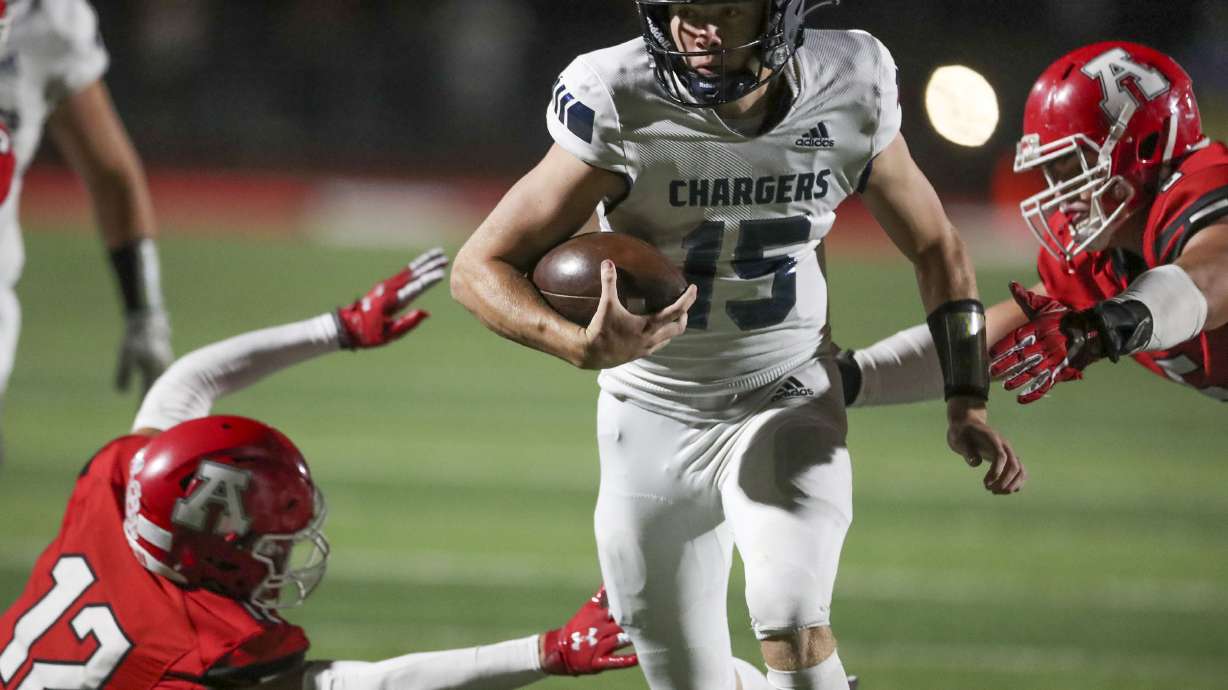 Corner Canyon QB Devin Brown runs through American Fork’s Davis Andrews (12) and Kyle Moore (11) at American Fork High School on Friday, Sept. 17, 2021.
