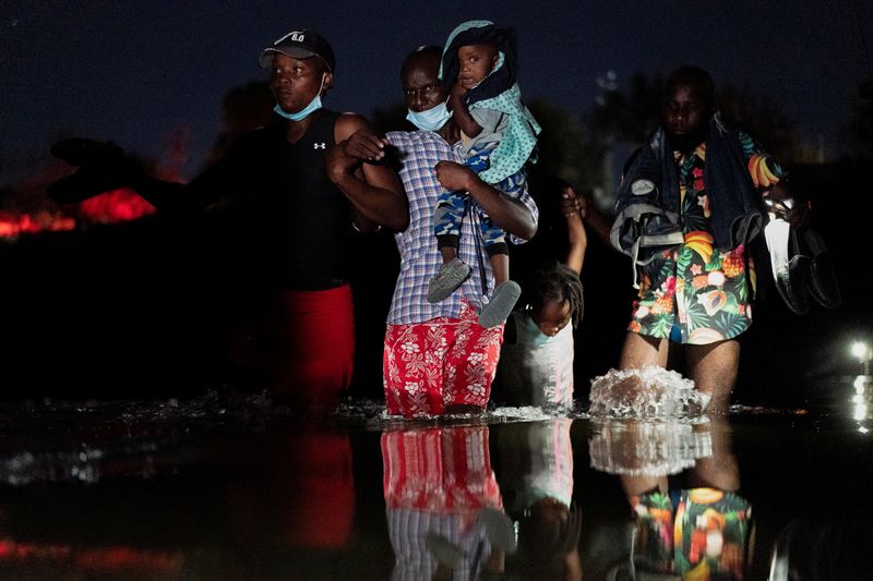 Migrants seeking asylum in the U.S. walk in the Rio Grande river to cross into the U.S. near the International Bridge between Mexico and the U.S. in Ciudad Acuna, Mexico, on Saturday.