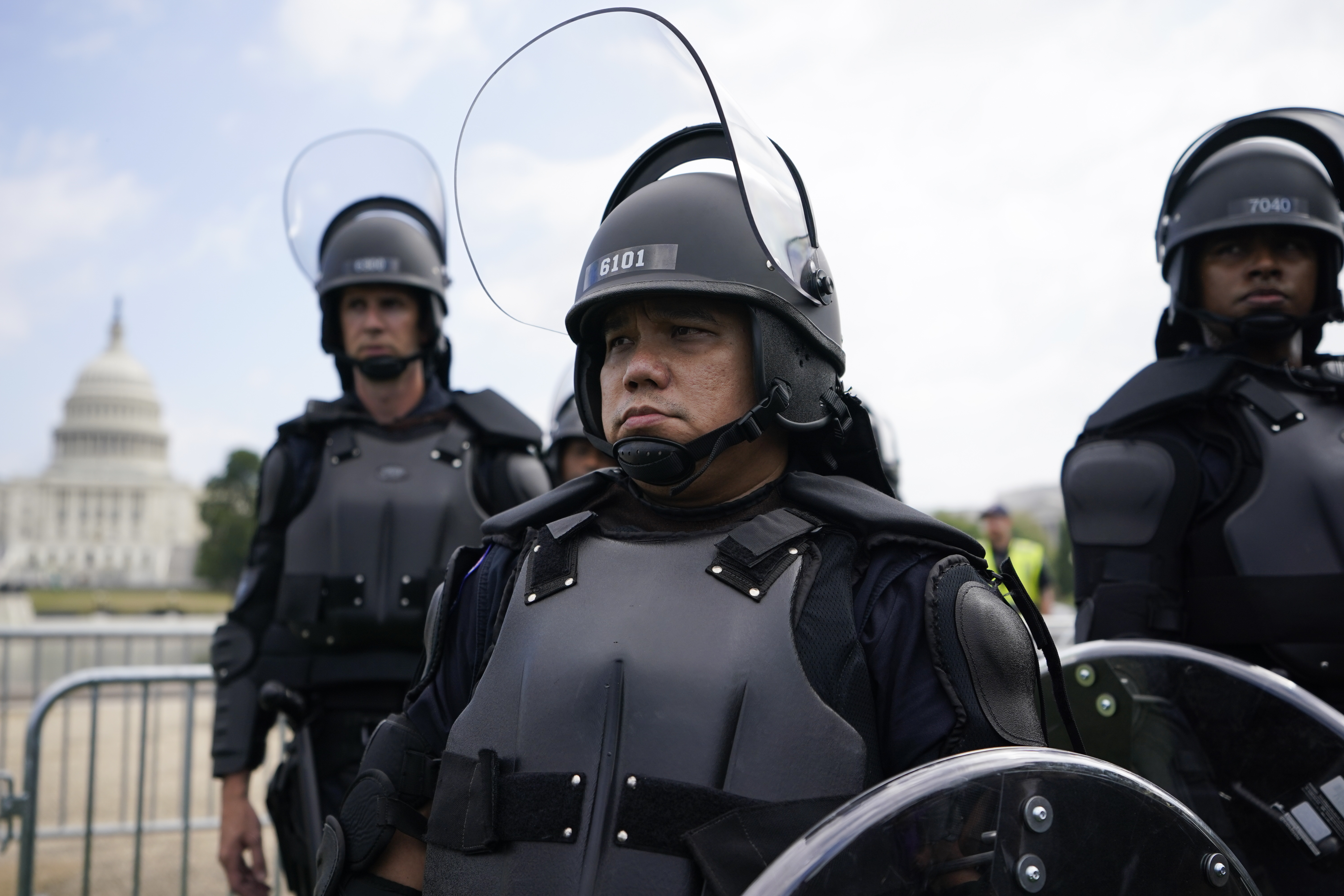 Police in riot gear patrol as people attend a rally near the U.S. Capitol in Washington, Saturday. The rally was planned by allies of former President Donald Trump and aimed at supporting the so-called "political prisoners" of the Jan. 6 insurrection at the U.S. Capitol.