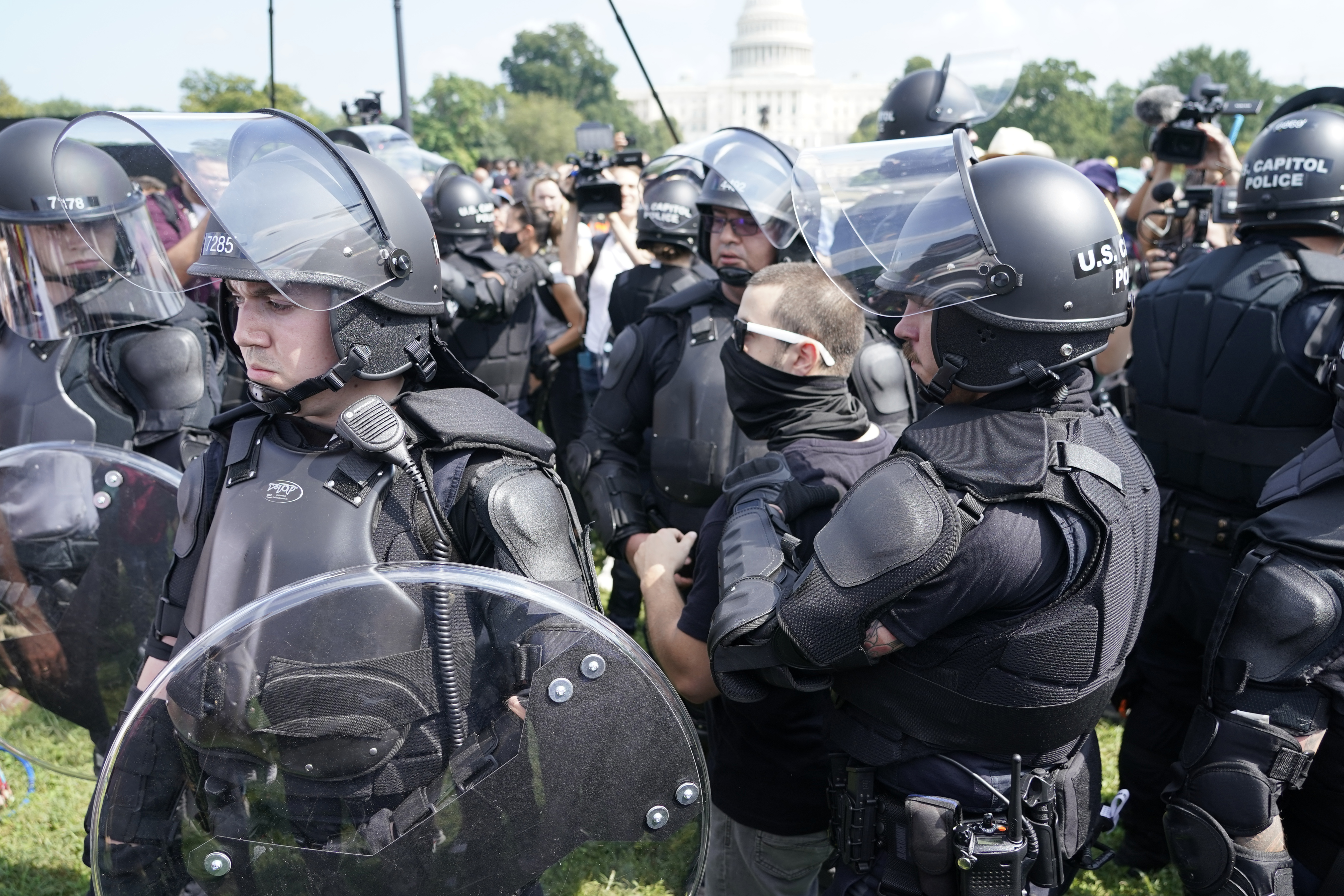 Police circle a man, center with glasses, during a rally near the U.S. Capitol in Washington, Saturday. The rally was planned by allies of former President Donald Trump and aimed at supporting the so-called "political prisoners" of the Jan. 6 insurrection at the U.S. Capitol.
