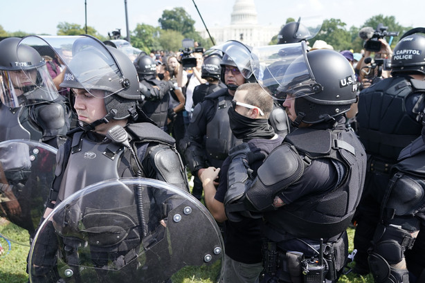 Police circle a man, center with glasses, during a rally near the U.S. Capitol in Washington, Saturday. The rally was planned by allies of former President Donald Trump and aimed at supporting the so-called "political prisoners" of the Jan. 6 insurrection at the U.S. Capitol.