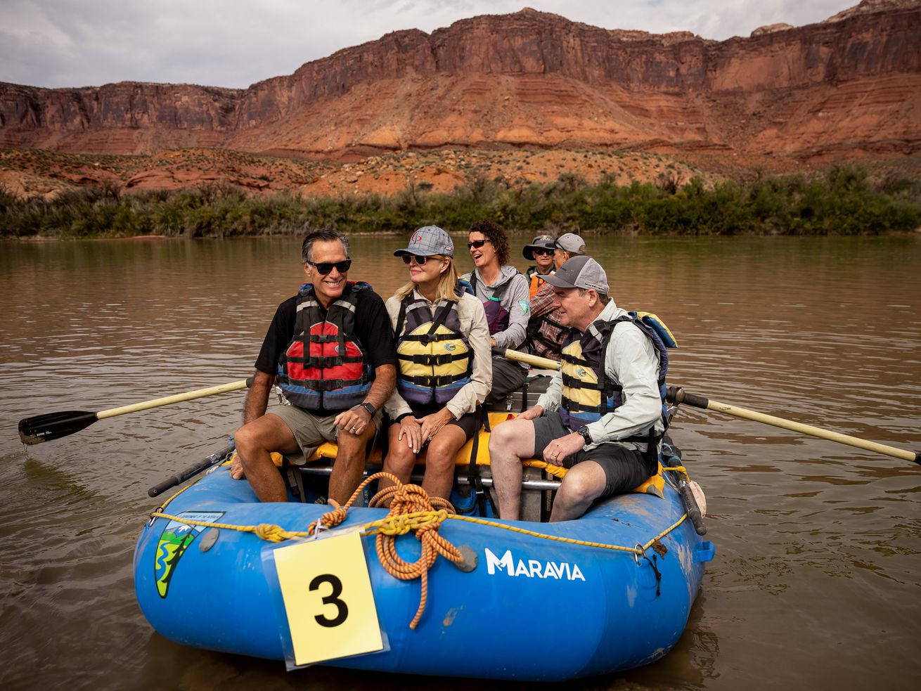 Sen. Mitt Romney, R-Utah, left, his wife, Ann, and Sen.
Michael Bennet, D-Colorado, sit together in a raft while they float a
section of the Colorado River northeast of Moab on Saturday.