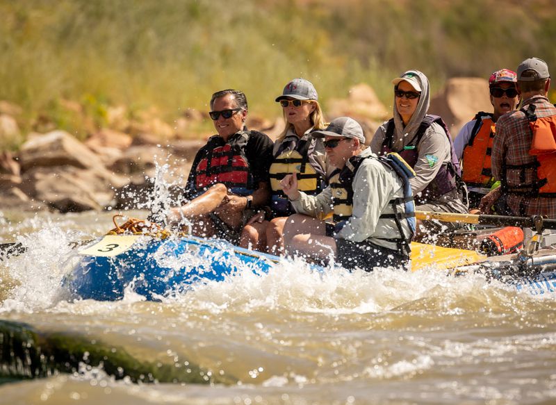 Sen. Mitt Romney, R-Utah, left, his wife, Ann, and Sen.
Michael Bennet, D-Colorado, sit together in a raft while they float a
section of the Colorado River northeast of Moab on Saturday.