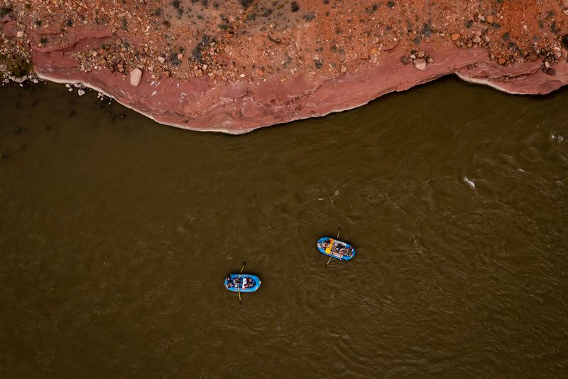A raft carrying Sen. Mitt Romney, R-Utah, his wife,
Ann, and Sen. Michael Bennet, D-Colorado, right, floats down a section
of the Colorado River northeast of Moab on Saturday.