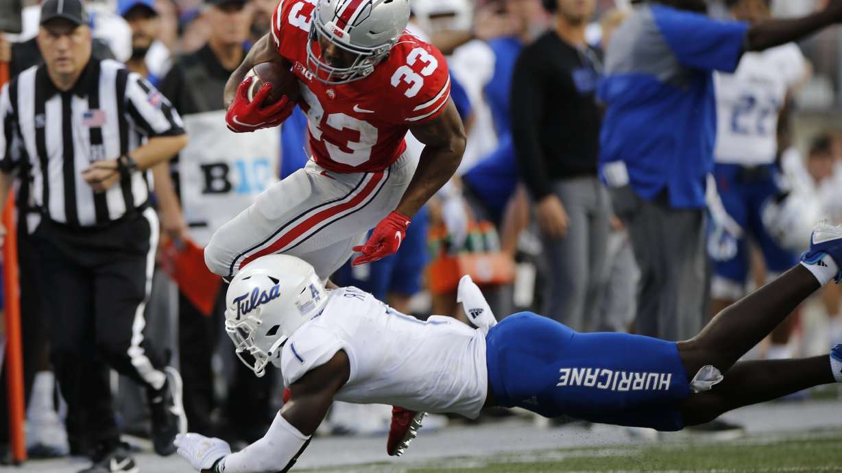 Ohio State running back Master Teague (33) tries to run past Tulsa defensive back Kendarin Ray during the second half of an NCAA college football game Saturday, Sept. 18, 2021, in Columbus, Ohio.