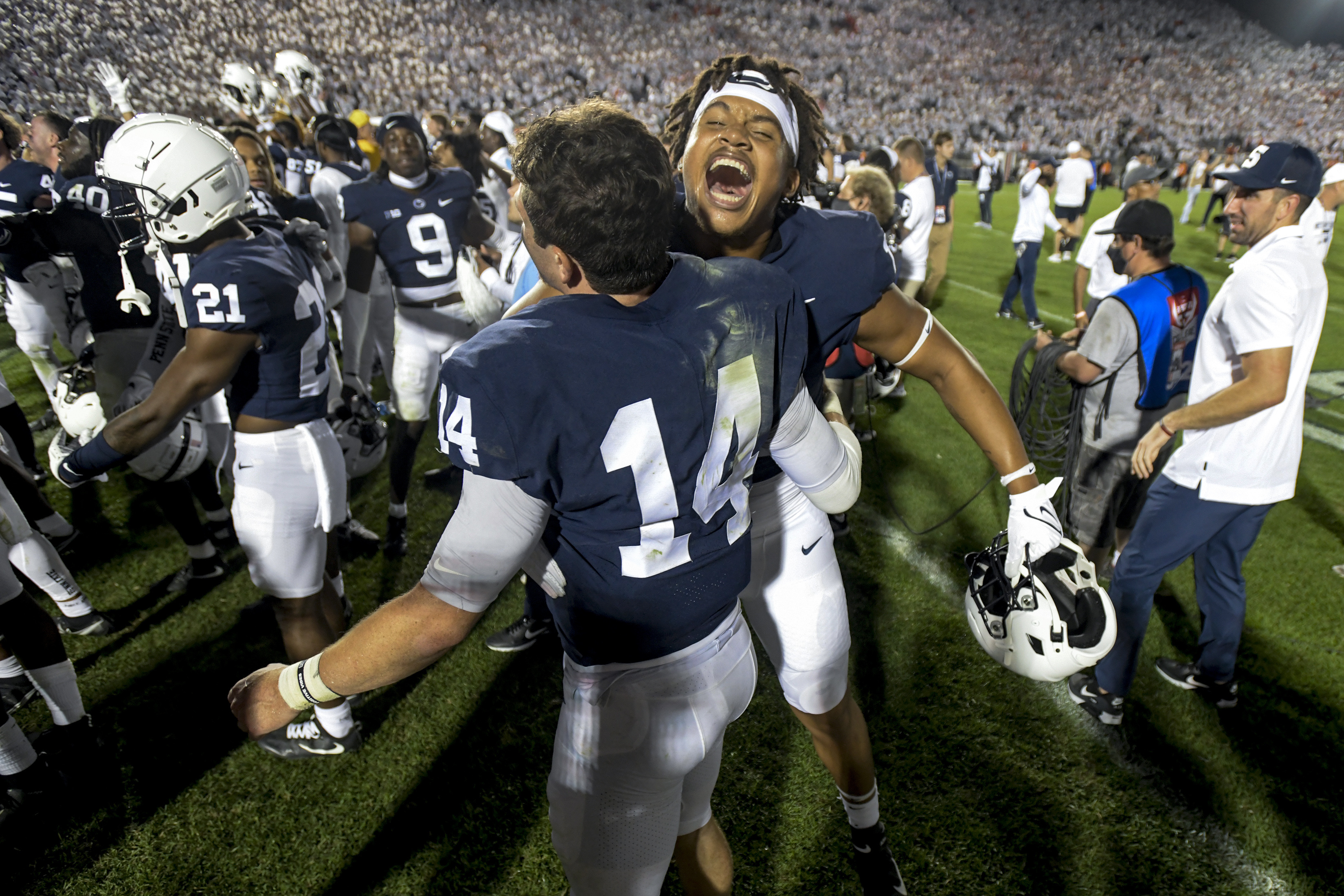 Penn State quarterback Sean Clifford (14) and defensive end Davon Townley (18) celebrate the 28-20 victory over Auburn in an NCAA college football game in State College, Pa., on Saturday, Sept. 18, 2021.