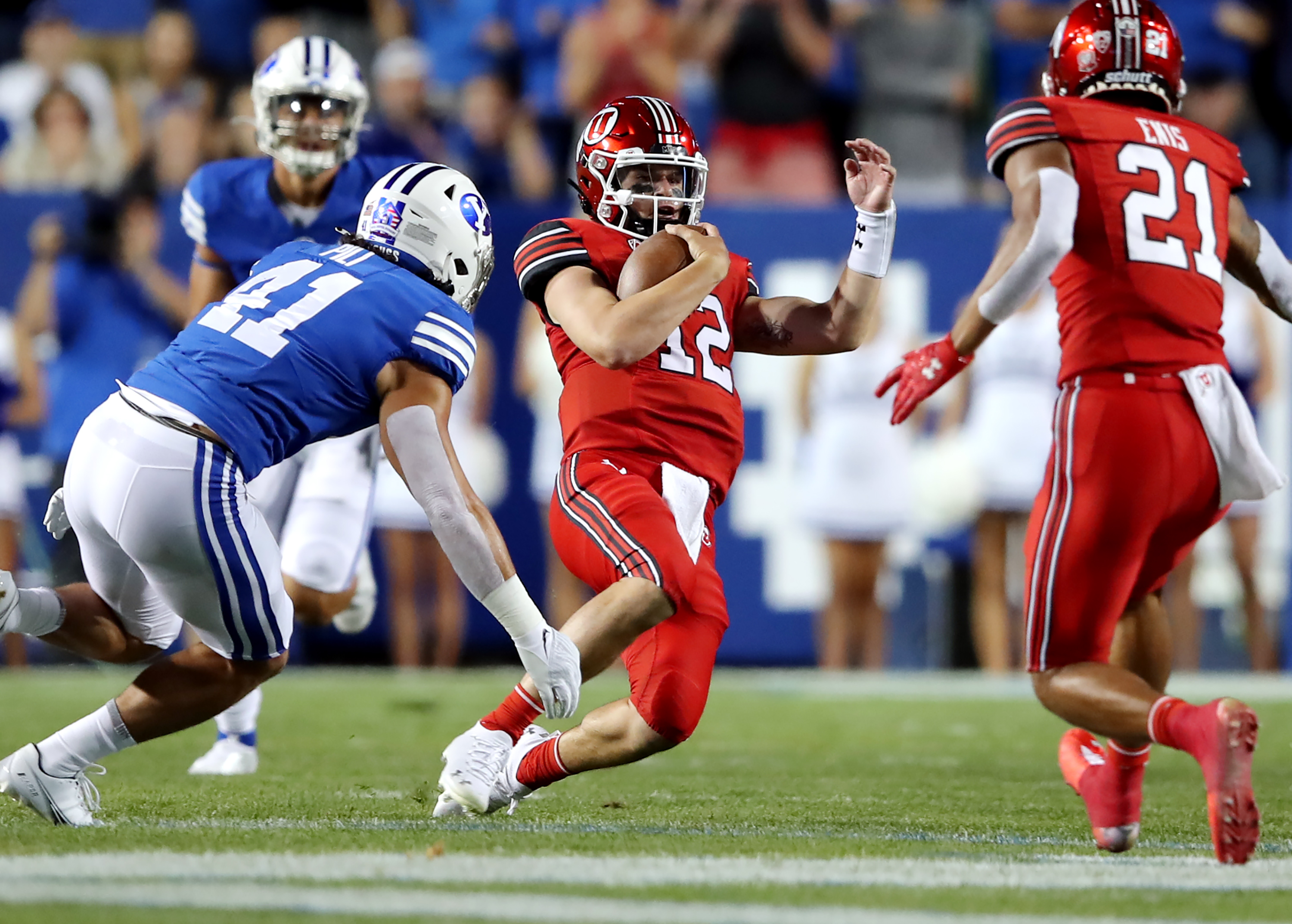 Utah Utes quarterback Charlie Brewer (12) slides down with Brigham Young Cougars linebacker Keenan Pili (41) moving in as BYU and Utah play an NCAA football game at LaVell Edwards Stadium in Provo on Saturday, Sept. 11, 2021.