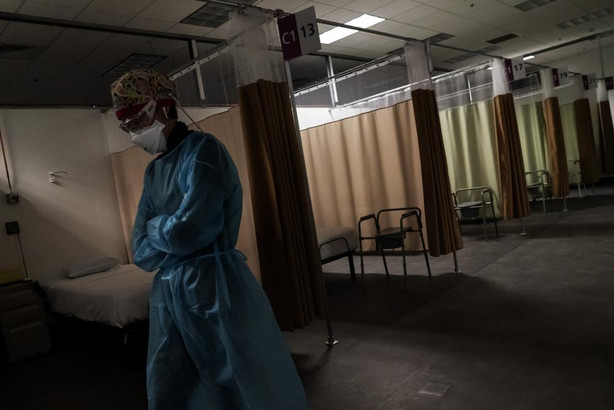 In this Feb. 10 photo, traveling registered nurse Patricia Carrete, of El Paso, Texas, walks down the hallways during a night shift at a field hospital set up to handle a surge of COVID-19 patients in Cranston, Rhode Island.